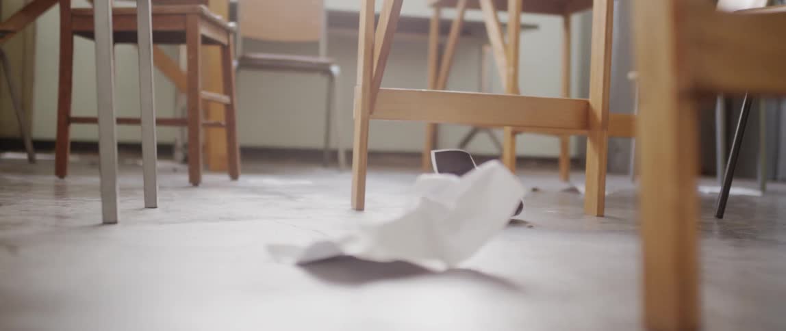 Paper litters the floor of the class