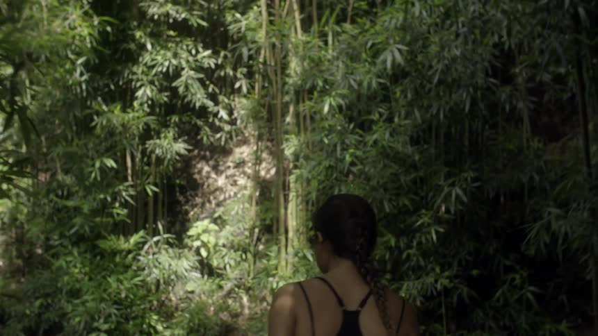A woman walks through a forest trail