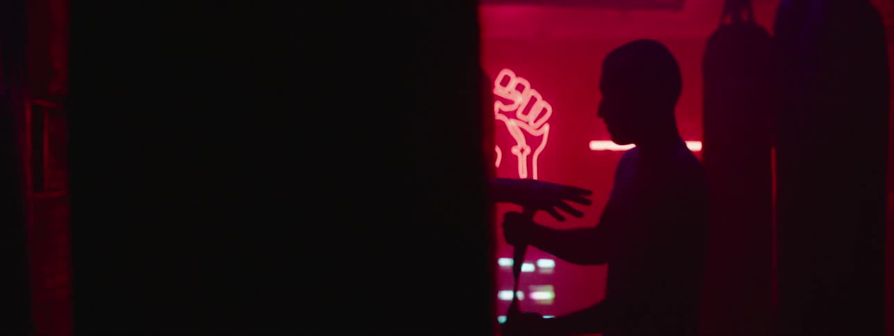 A man in a red room is getting his wrists taped