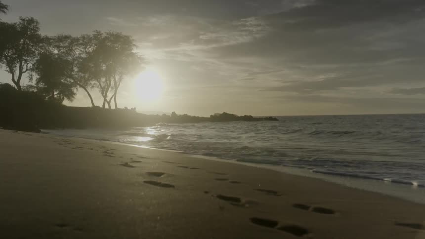 Waves crash ashore as the sun shines