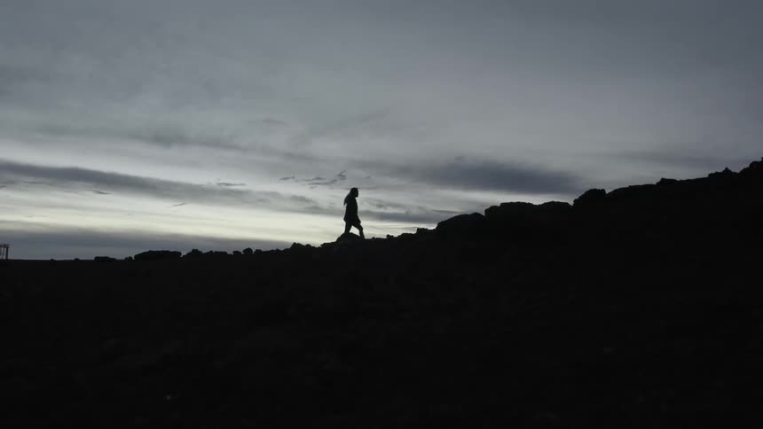 A woman hikes up a hill