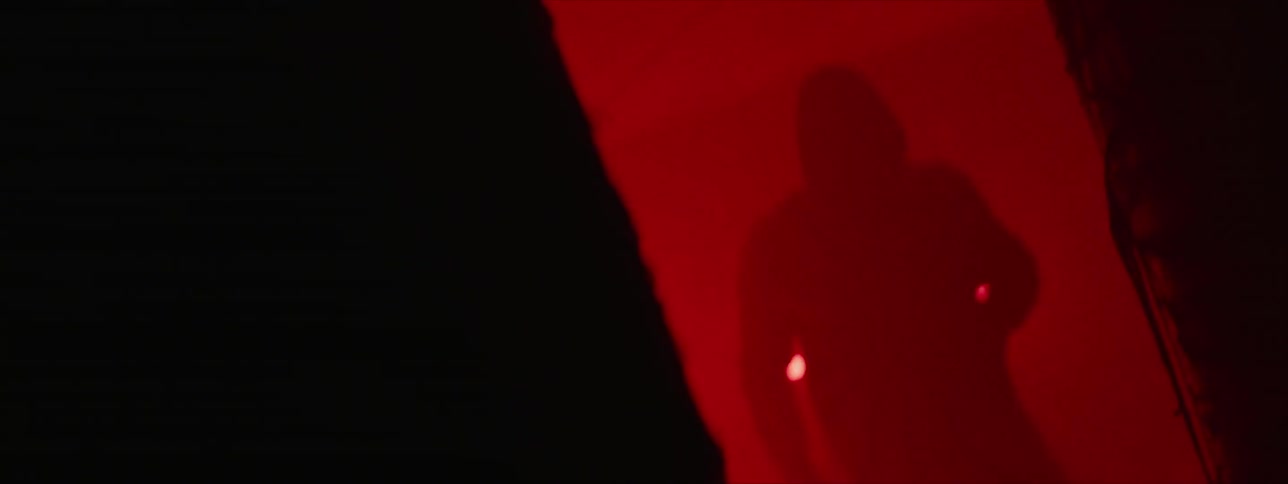 A man stands in a gym lit with neon lights