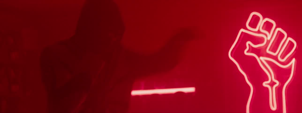 A man shadow boxes in a neon lit gym