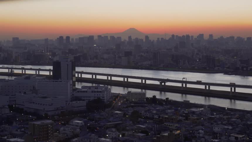 The vehicles drive over the bridge at dawn