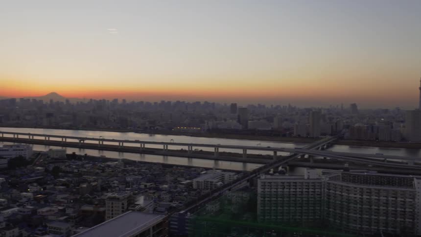 Sun sets over a river and large city