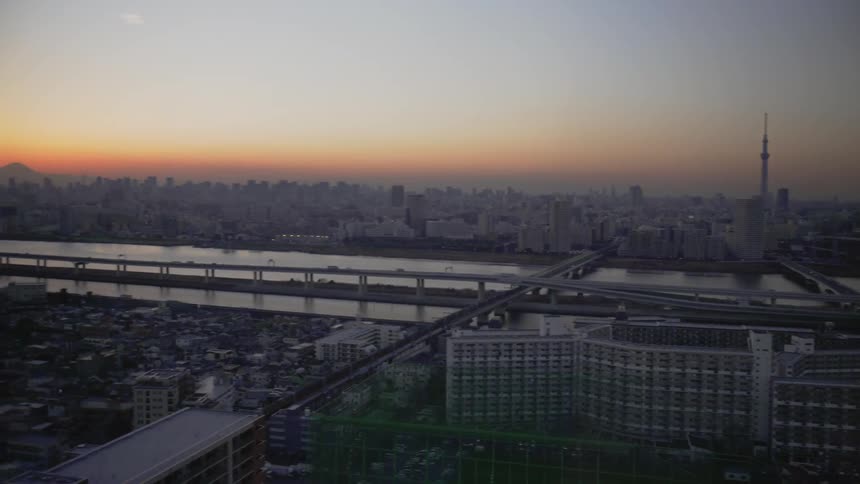 Sun sets over a river and large city