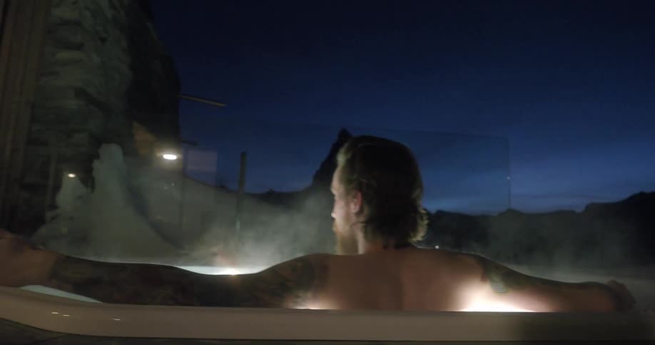 A man sits in a steaming hot tub