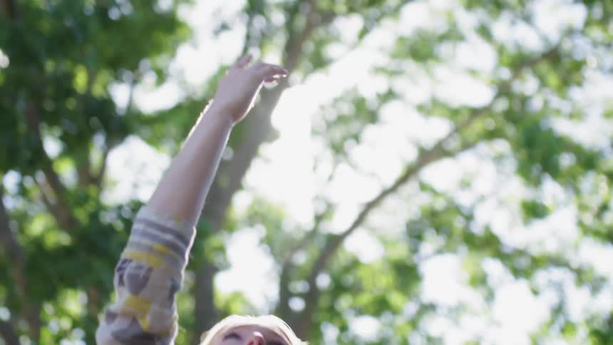 A woman waves her hand around at the sky