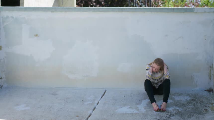 A woman sits with her head in her hands
