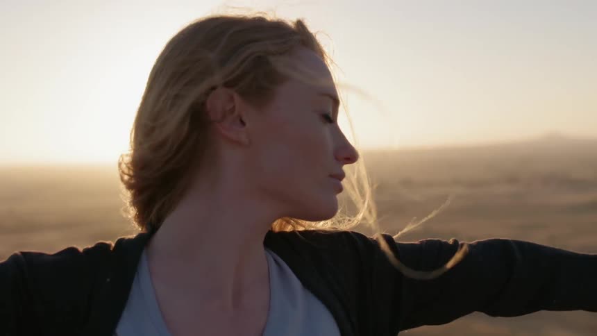 A woman sticks her arms out as the wind blows