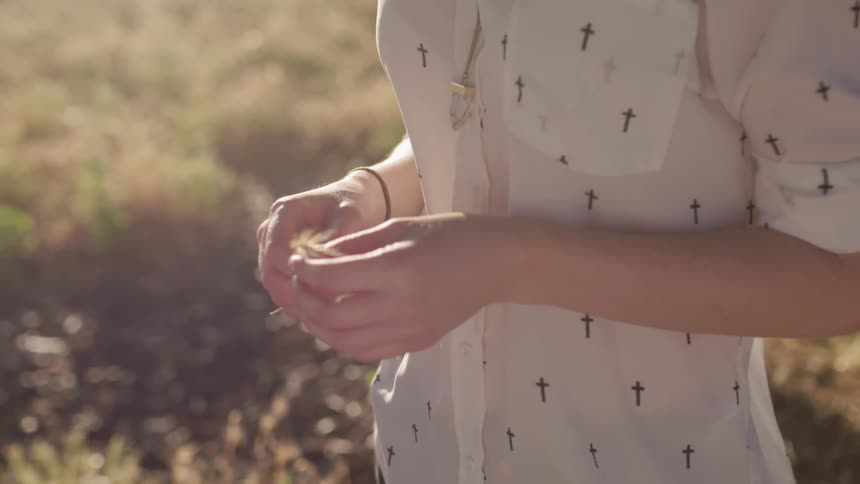 A woman stands in a field on a sunny day