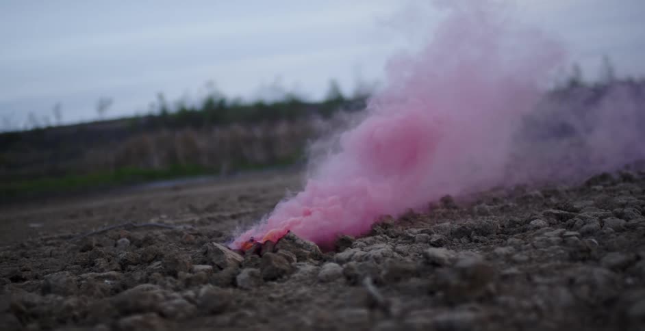 Pink smoke rises up from the rocks