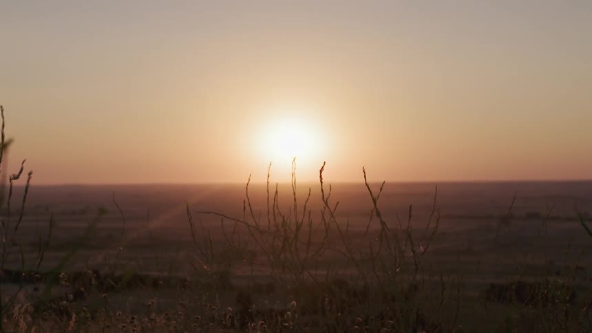 The sun sets over a rural field