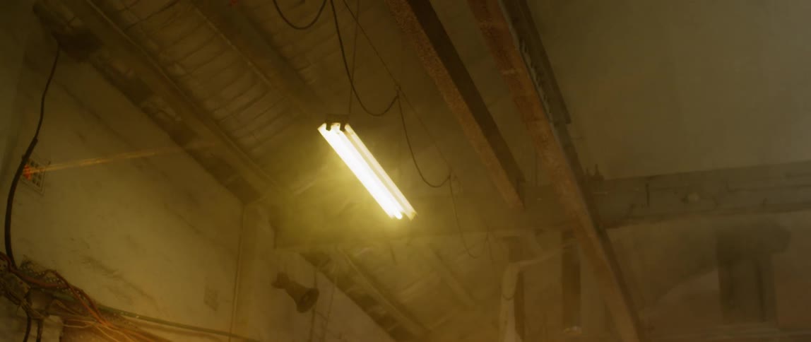A shop light flickers and turns on brightly