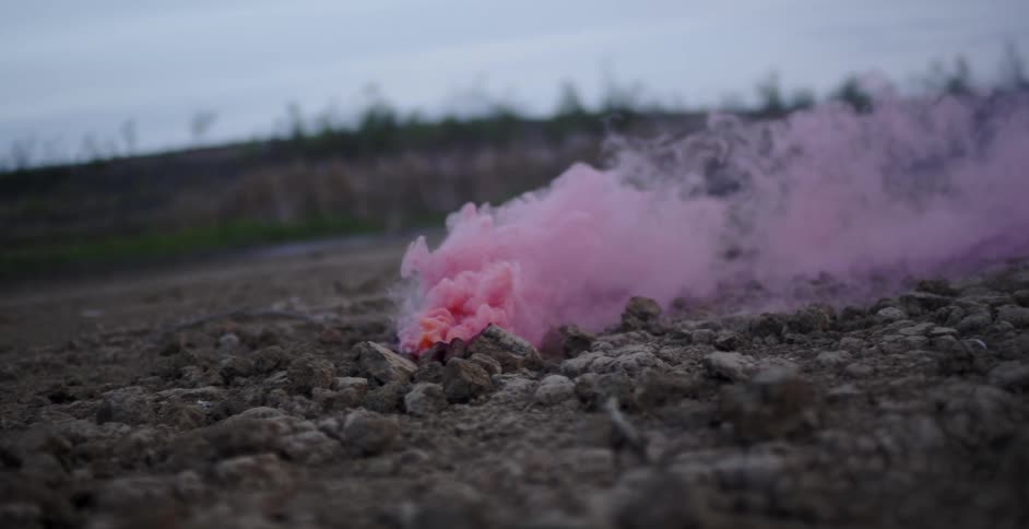 Pink smoke rises from the ground