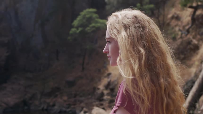 Wind blows through a woman's long hair in mountains