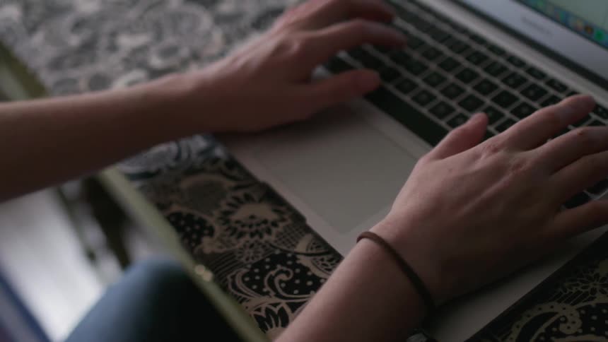 A woman uses a laptop at a desk