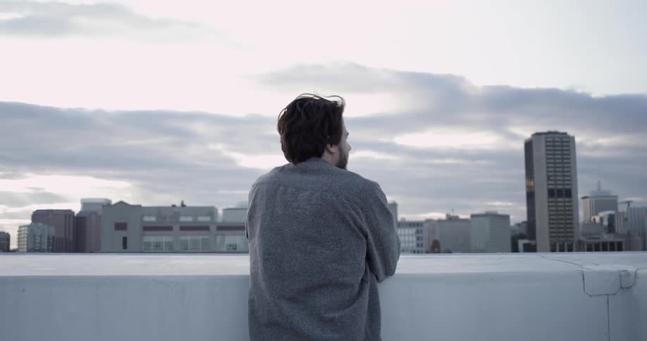 A man observes the city from a rooftop
