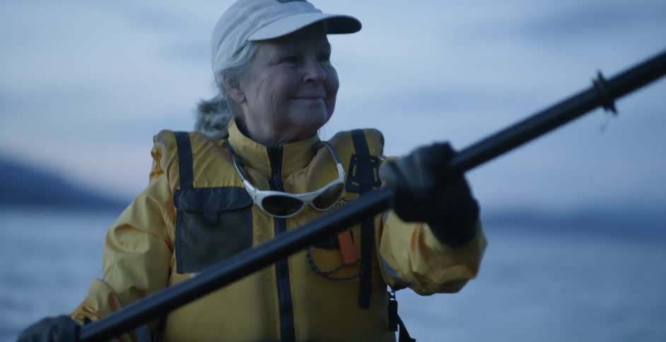 A woman kayaks on a lake