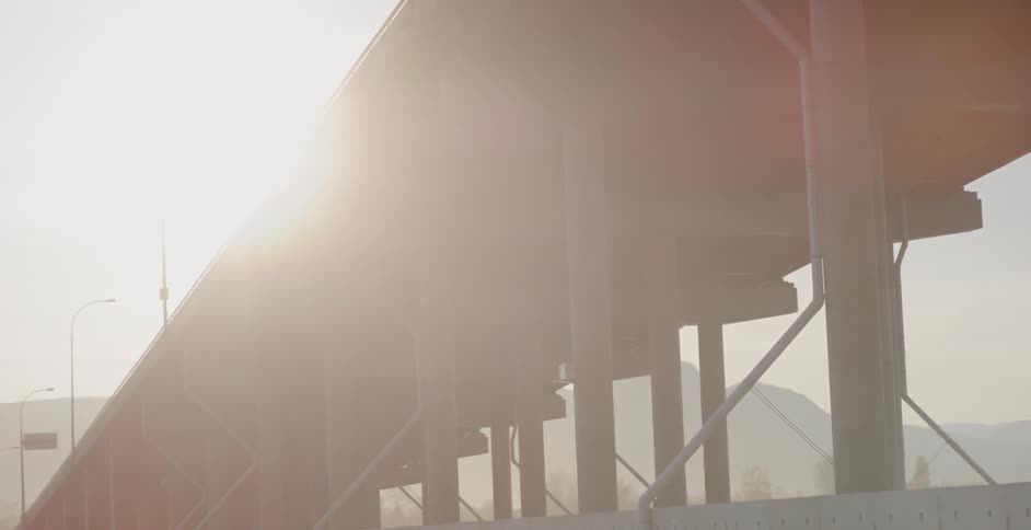 Sunlight shining over city overpass bridge