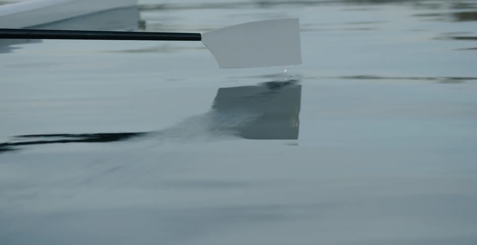 A person paddles on a rowboat