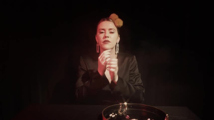 A woman puts earrings on at a table
