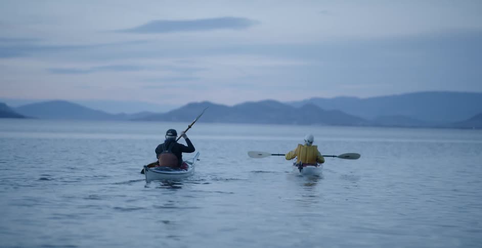 Two people paddle canoes in the lake