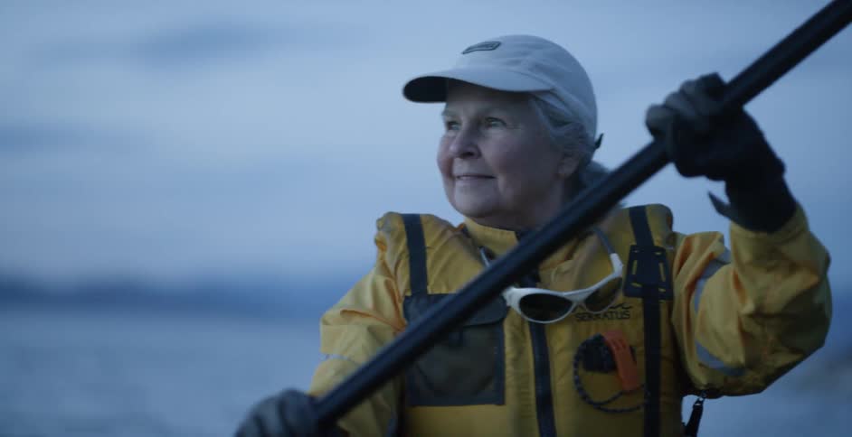 A woman kayaks on a lake