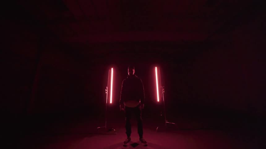 Man in a dark tunnel by red lights