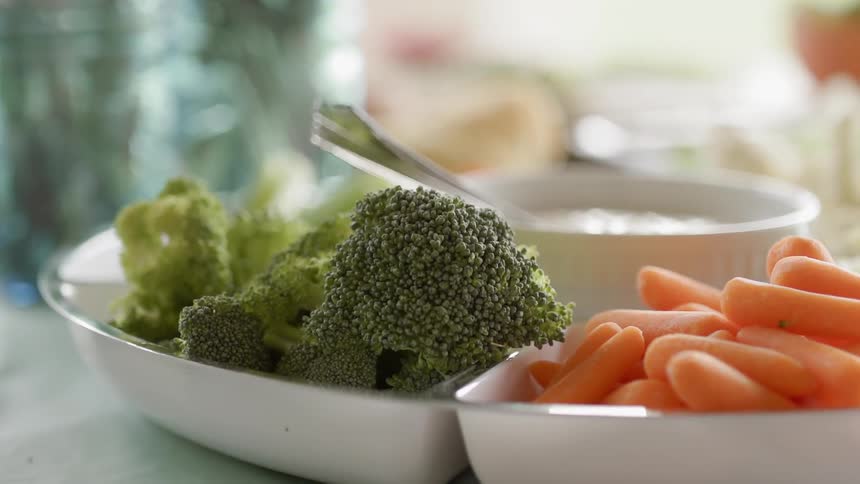 Bowl of dip sits surrounded by vegetables