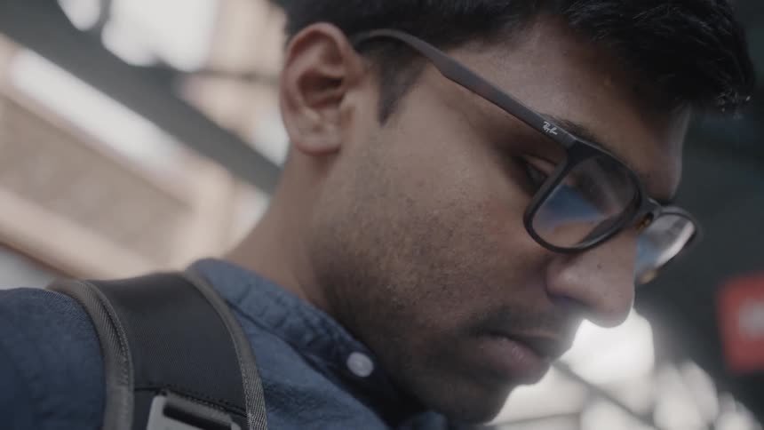 Man stands looking at smartphone