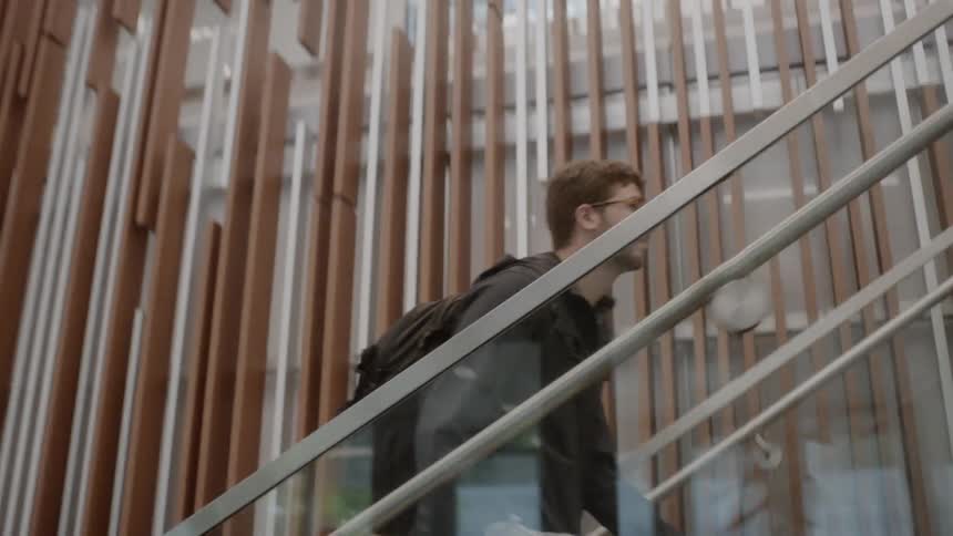 A man climbs up stairs with a backpack