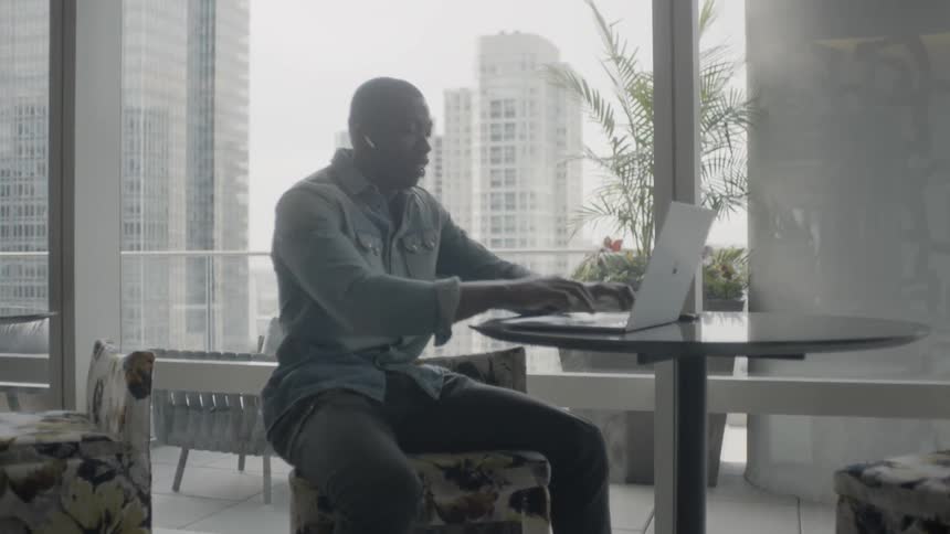 Man sitting at a desk looking at a laptop