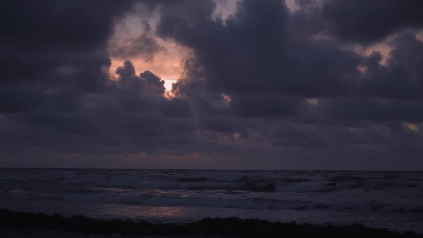 Clouds float above a beach at sunset