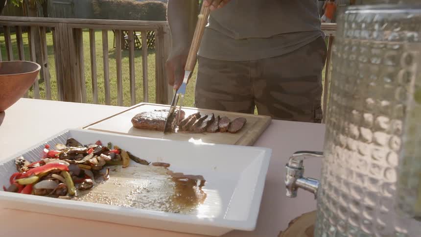 Man cutting meat on a table outside