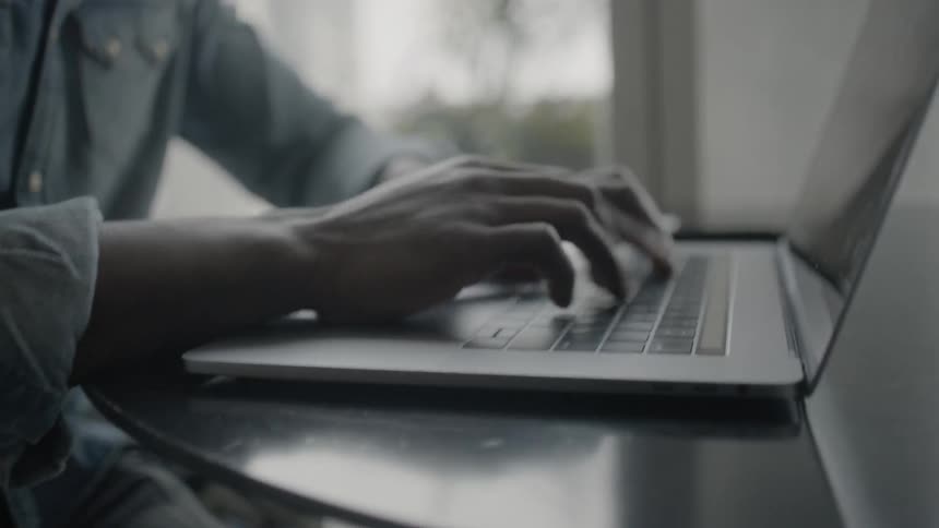 A man working inside on a laptop