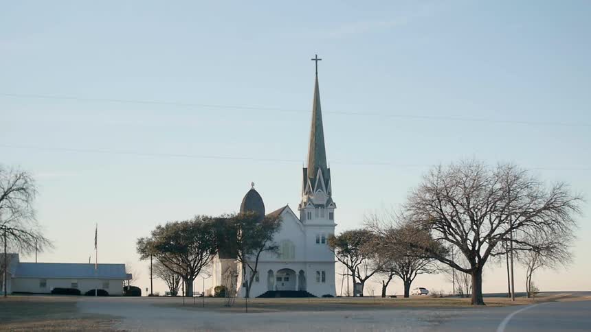 Sun sets behind a church