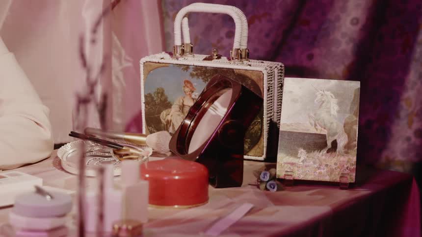 Makeup and mirror sit on a dressing table