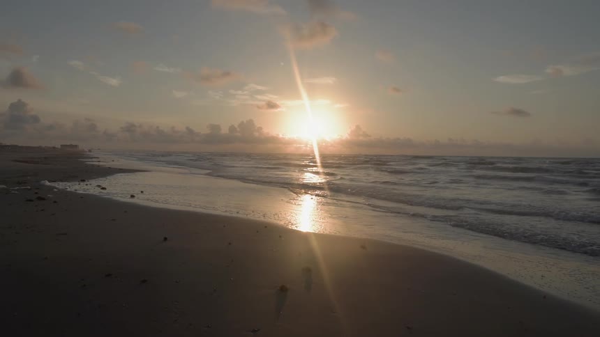 The sun sets over a beach