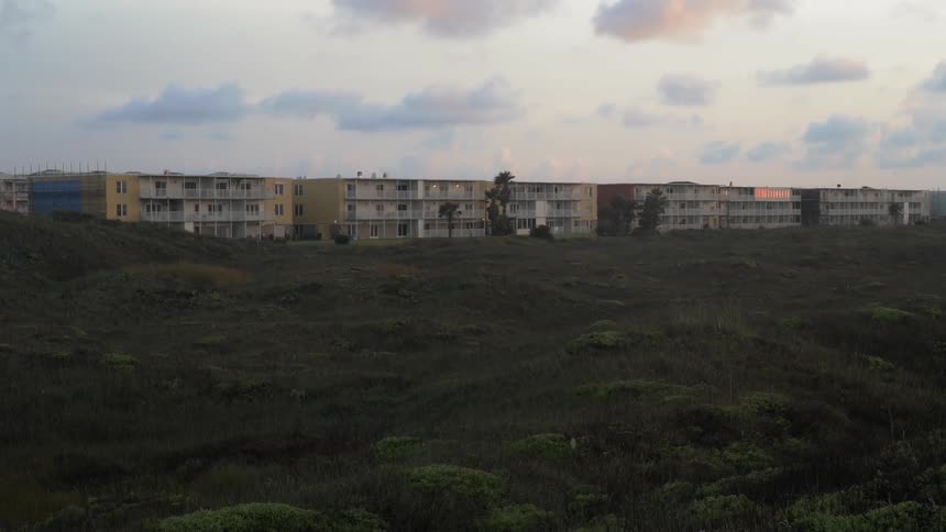 Clouds float above apartment complexes at sunset
