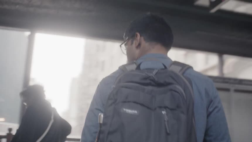 Man with backpack descends subway stairs