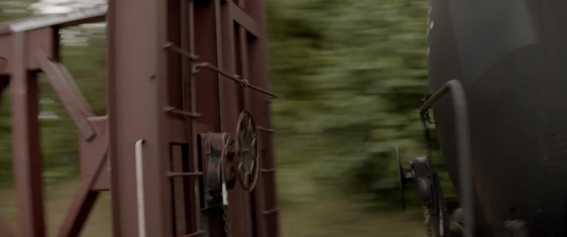 Train rolling down tracks in the forest
