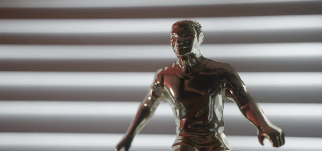 A soccer trophy sits in front of a window
