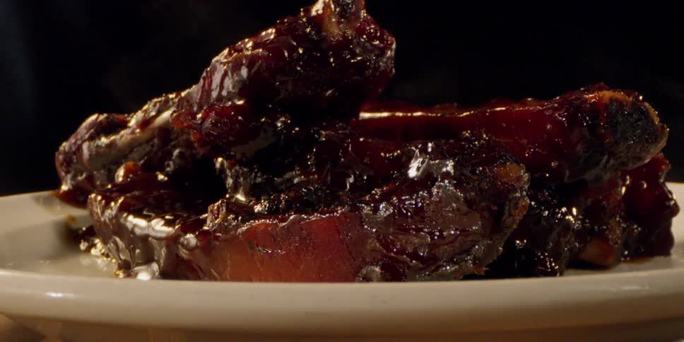 Steam is rising off a plate of barbecued ribs