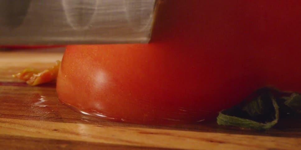 Knife slices through tomato