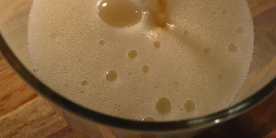 Beer pours into a glass mug