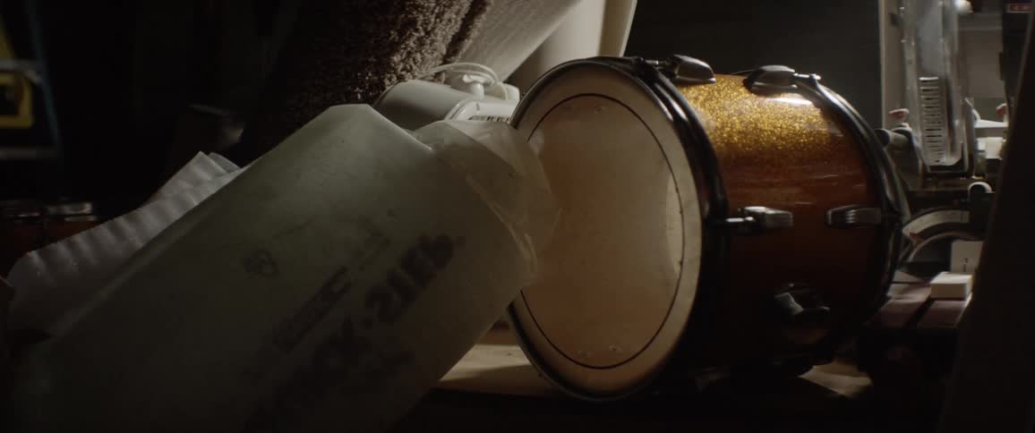 Gold colored drum sits on its side on a table