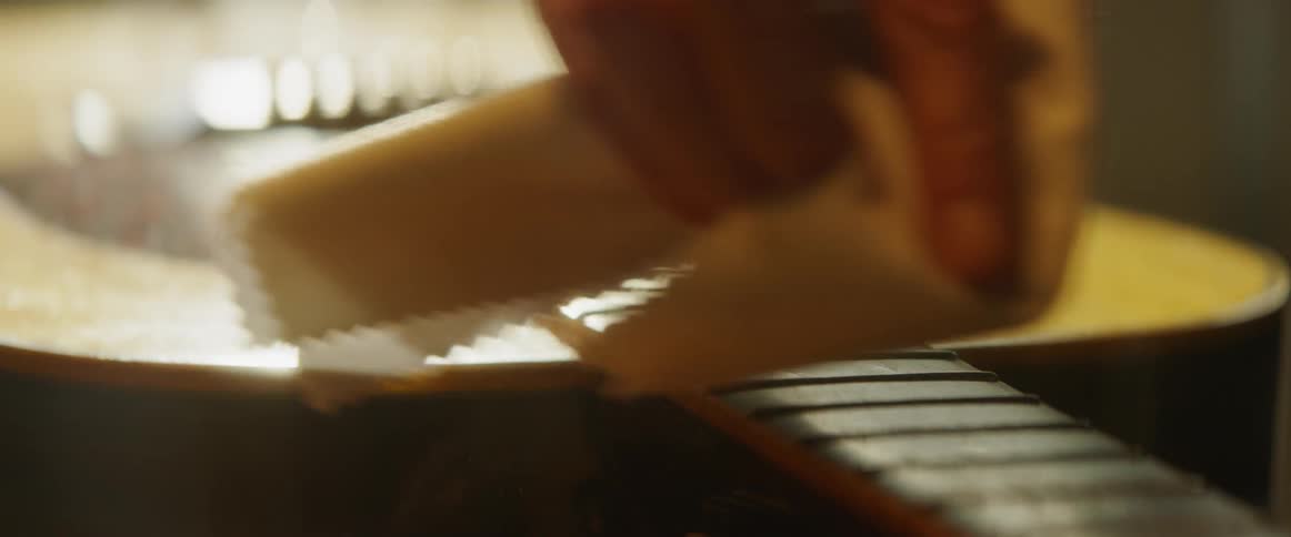 A person is wiping the guitar strings