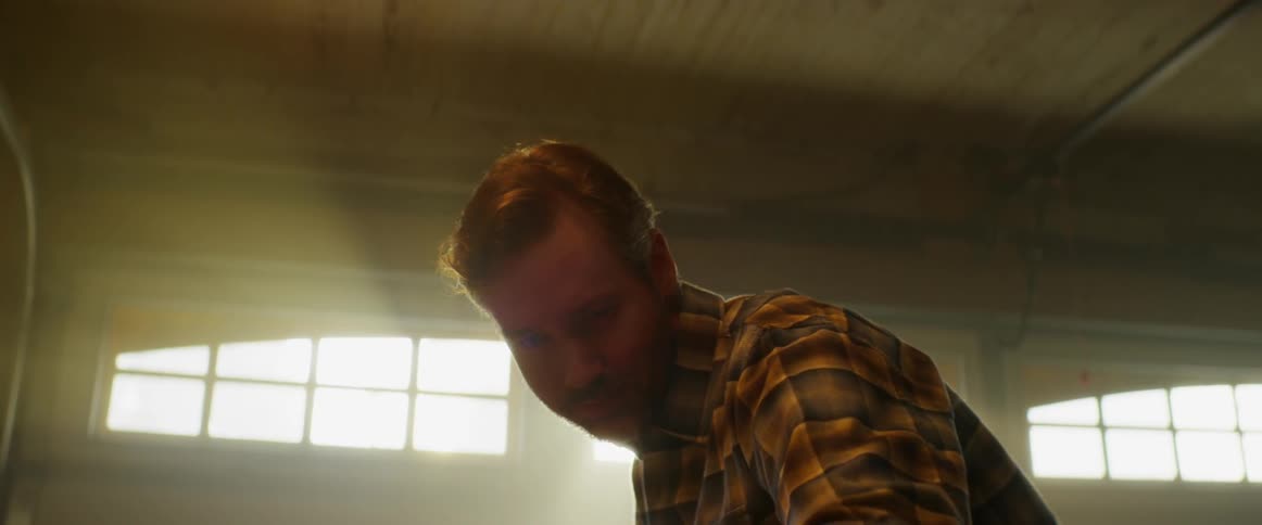 Man looks down and examines something