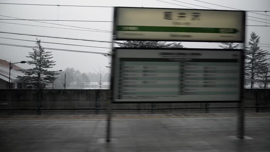 People stand on an elevated train platform